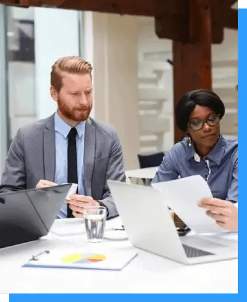Modern corporate meeting with diverse professionals discussing documents at a business table, showcasing teamwork, collaboration, and professional services.