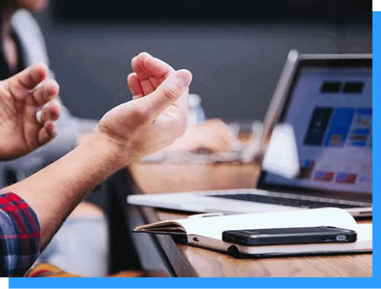 Modern business meeting with laptops, smartphones, and notebooks on a conference table, emphasizing technology, collaboration, and professional workspace environment.