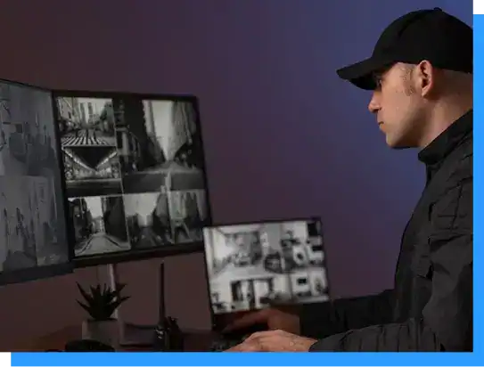 Multiple security monitors displaying surveillance footage, with a security professional managing security systems at Rivell.