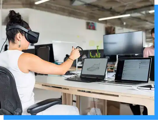 VR technology demonstration in a modern office with laptops and monitors, showcasing innovative workspaces and digital creativity.