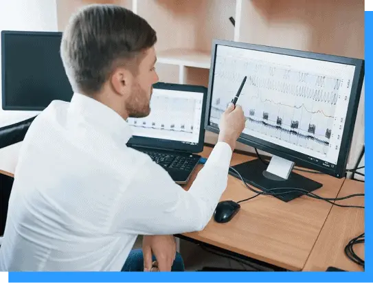 High-tech neuroscientist analyzing brain wave data on dual monitors for neurological research and diagnostics.