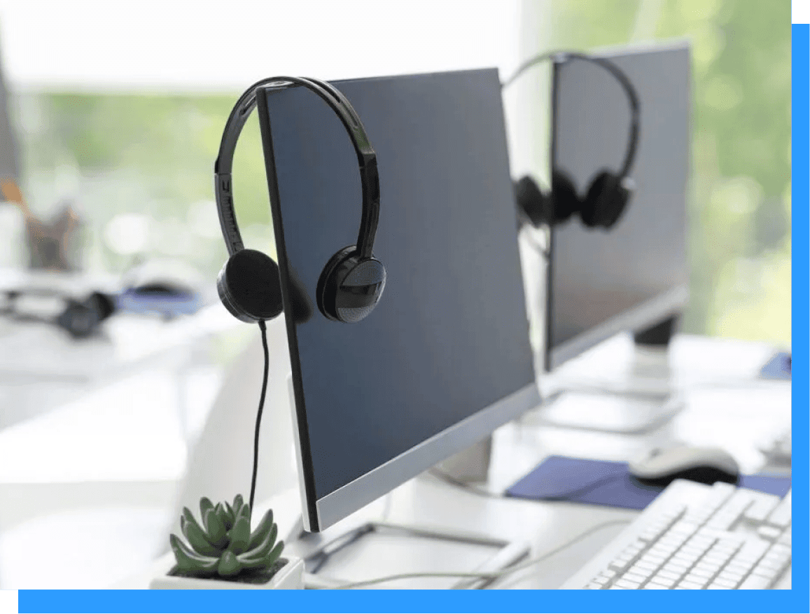 Wireless headphones hanging on monitor at modern tech workspace, ergonomic desk setup for remote work and online meetings, sleek black audio equipment, organized office with natural light, Rivell brand logo visible in background.