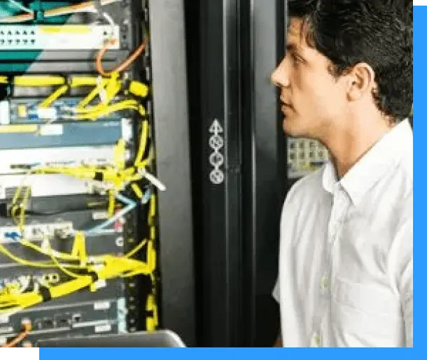 Fiber optic technician inspecting server room cabling and networking equipment.