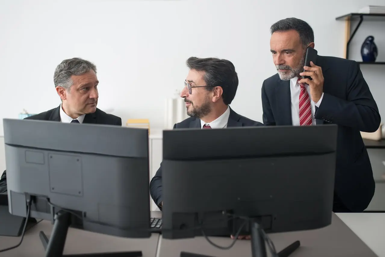 Fingerprint scanner placed on office desk alongside people in a business meeting, emphasizing secure access technology and professional communication solutions.