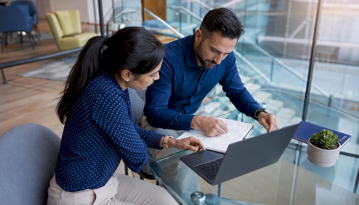 Two IT specialists collaborating at their desk