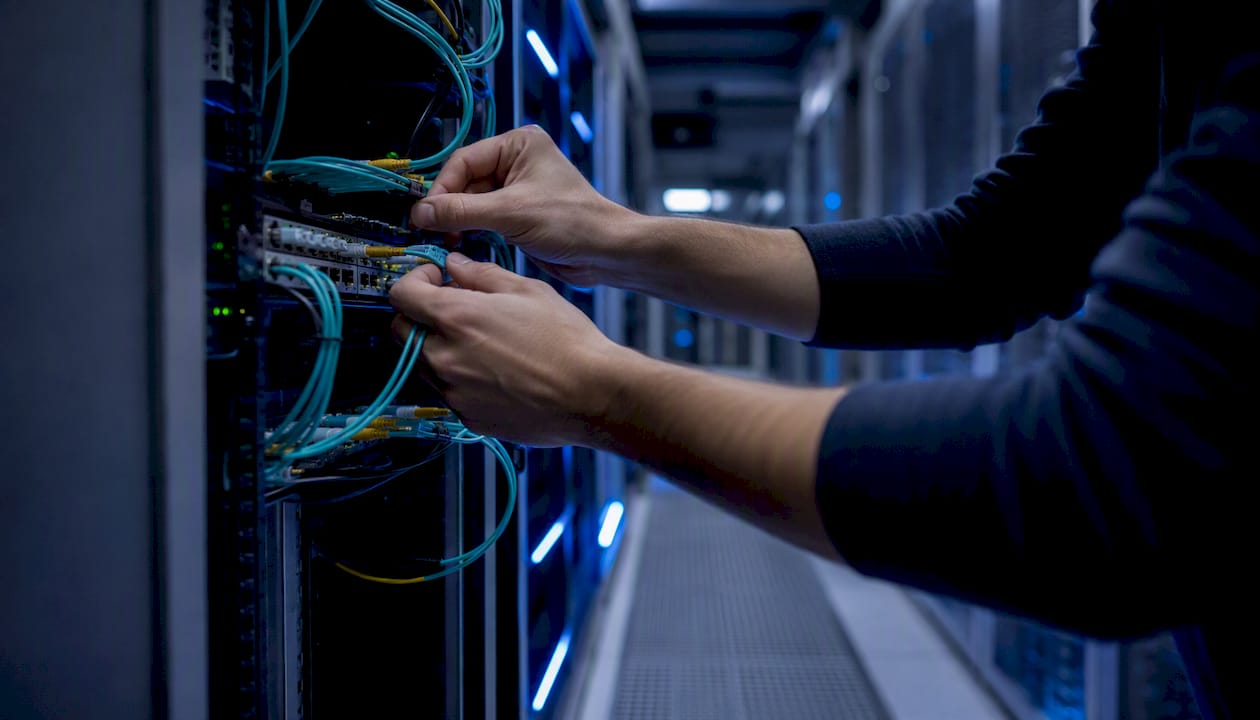 Hands connecting network cables in data center