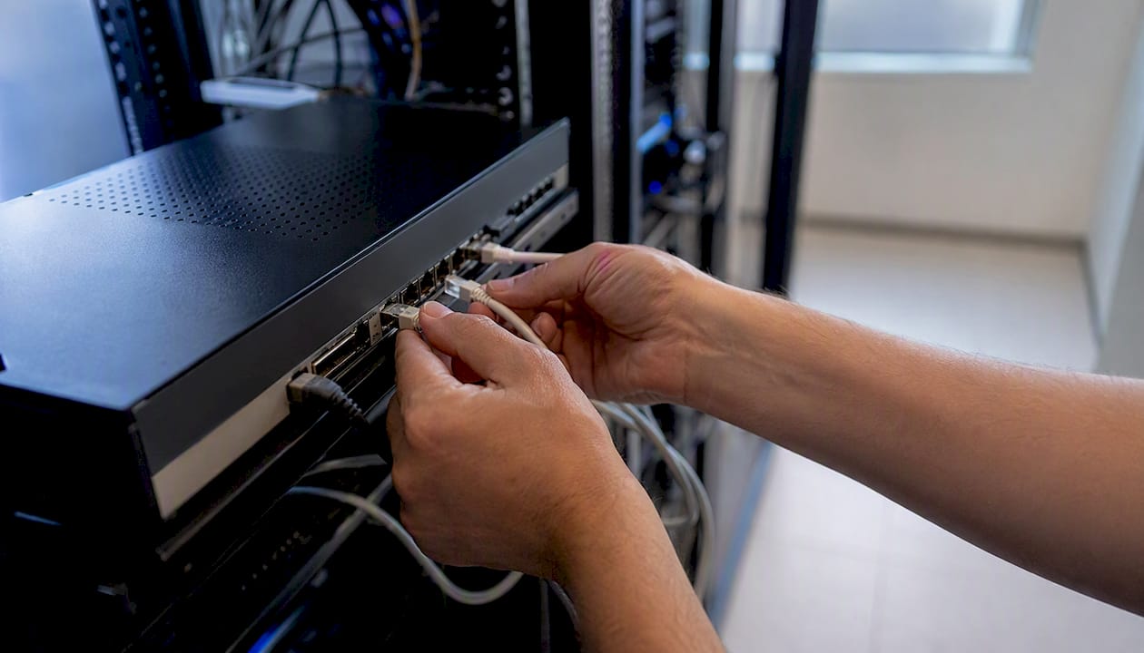 Hands connecting VoIP router cables