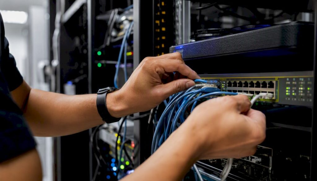 Hands configuring network gear in server room
