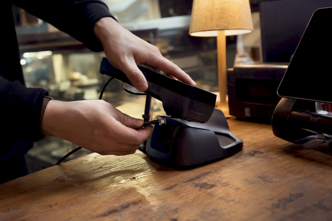 Hands installing secure payment terminal hardware